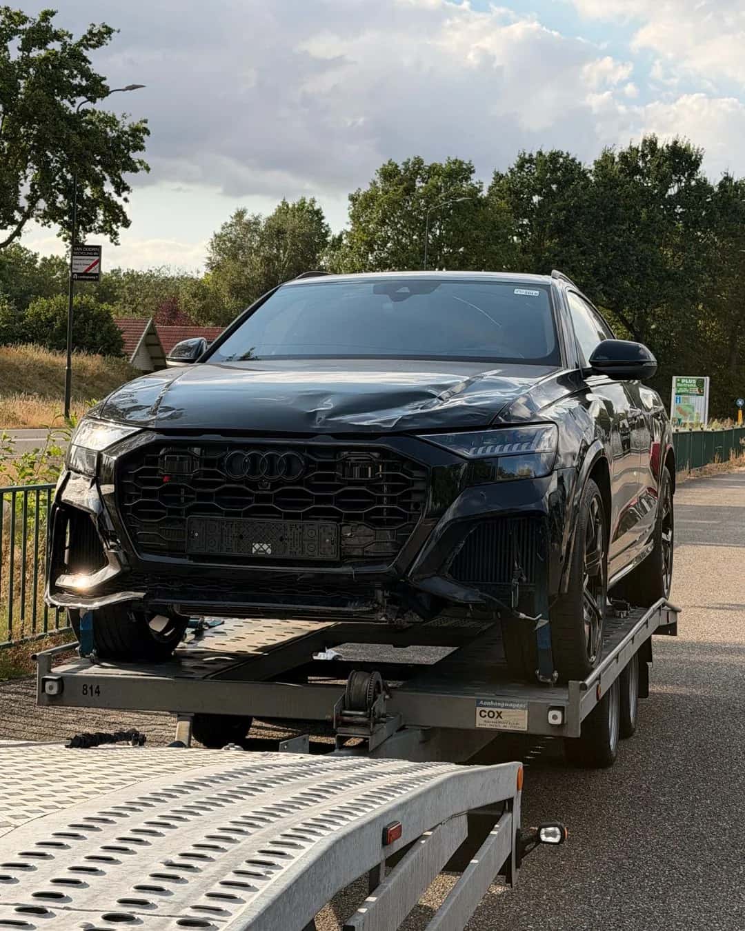 Beschadigde SUV gereed voor transport op een aanhanger