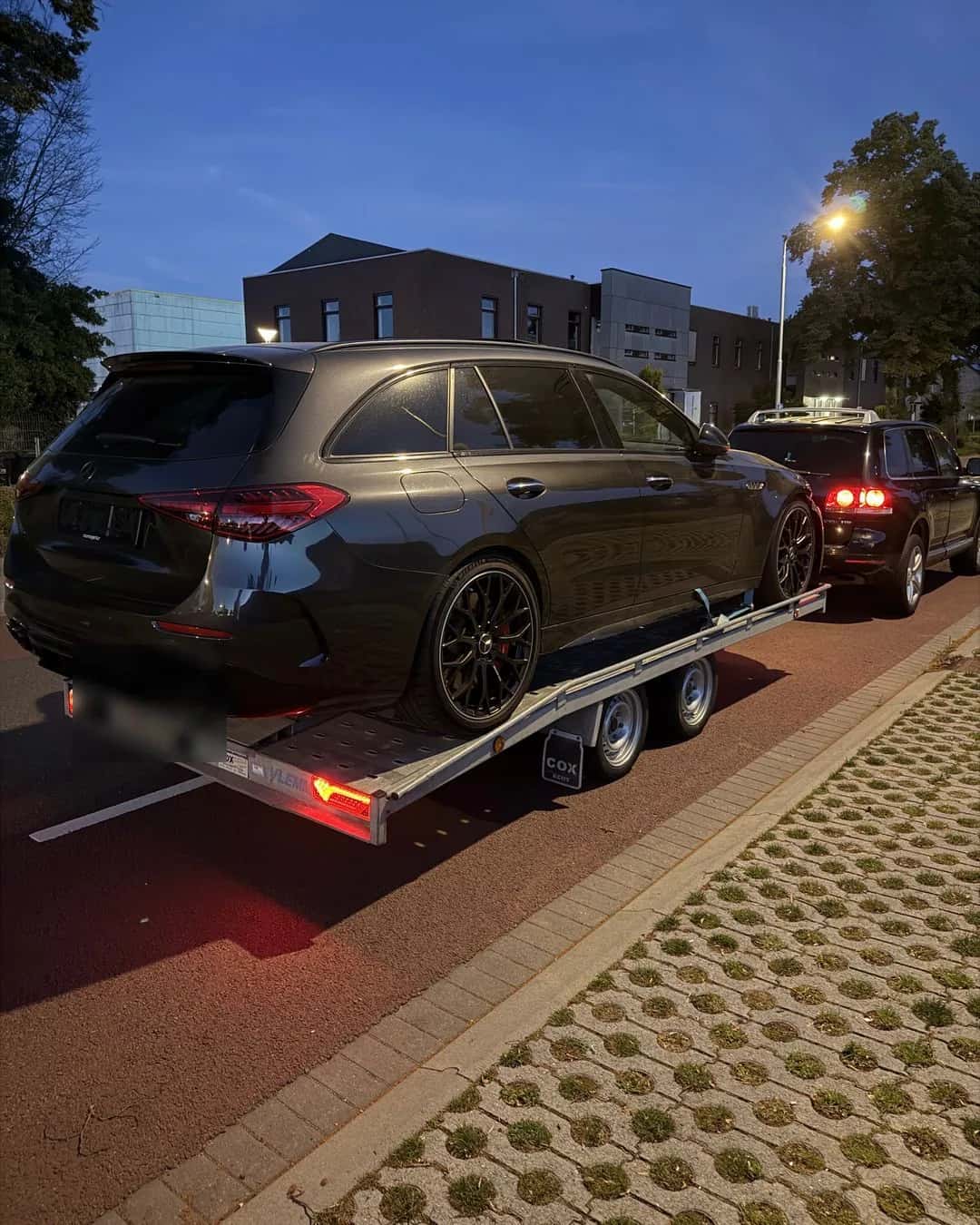 Premium stationwagen op een autotransporter in de avond