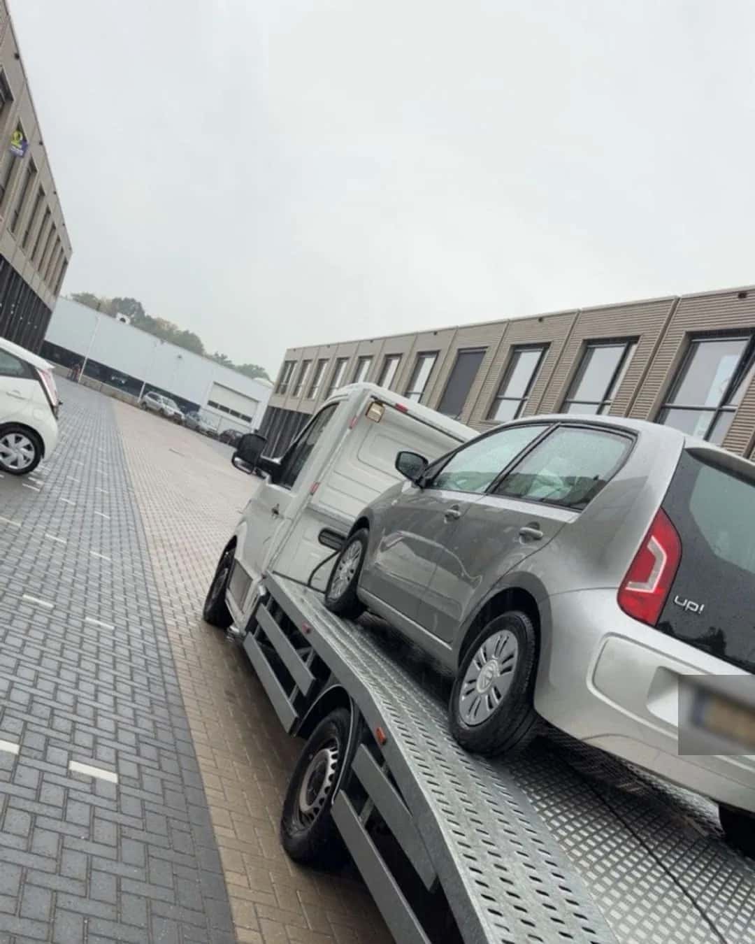 Compacte personenauto op de oprijwagen tijdens voertuigtransport
